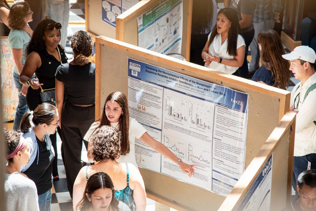 Students presenting poster at research forum.